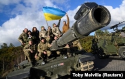 Украинские военнослужащие позируют на танке Challenger 2 на военной базе Bovington Camp на юго-западе Великобритании, 22 февраля 2023 года