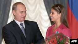 Prezident Vladimir Putin va badiiy gimnastika bo‘yicha Olimpiya chempioni Alina Kabayeva Kremldagi taqdirlash marosimida. 8-iyun, 2001-yil