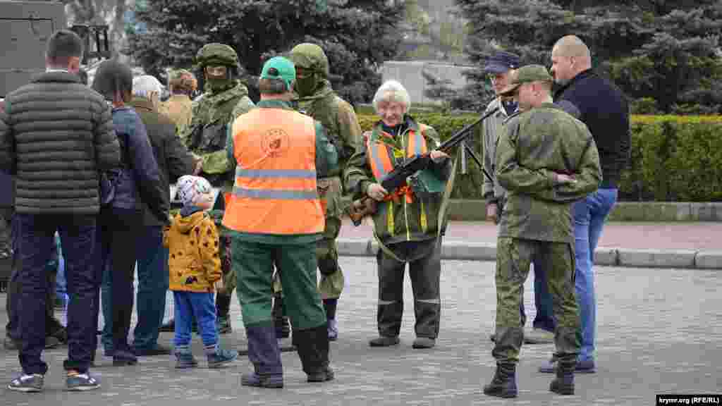 Пенсионерка с ручным пулеметом, рядом с ней российский военный