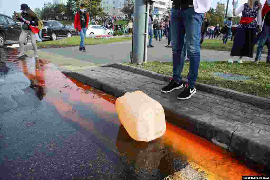 У водометов на улице Машерова оказались открытыми технические двери. Протестующие достали оттуда различные жидкости. Одной из жидкостей оказался оранжевый краситель с резким запахом