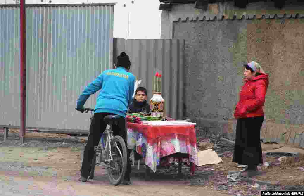 Алатау ауданы Алғабас ауылында көшеде гүл сатып алып жатқан адам.