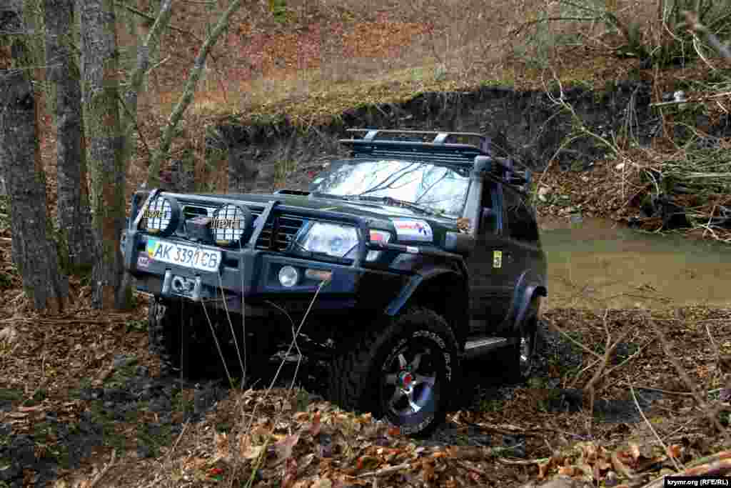 Внедорожник Jeep преодолевает горную месность